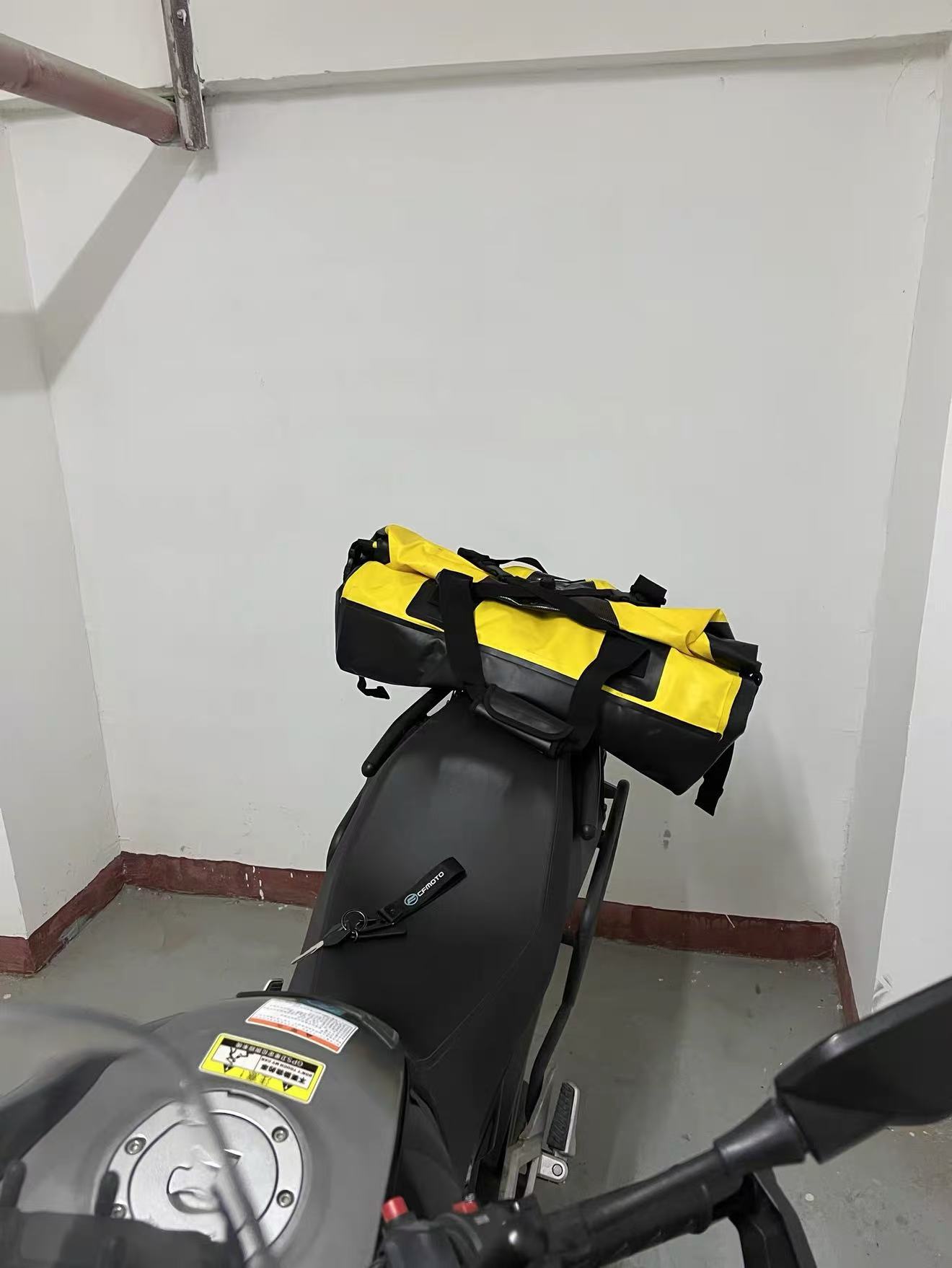 Motorcycle tail bag strapped to the passenger seat using grab rails, no luggage rack